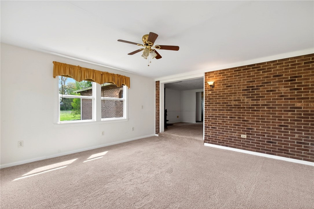 7988 McCool Road Greenville, OH 45331 - Photo 13 of 50 This inviting living area boasts ample natural light and a charming brick accent wall.