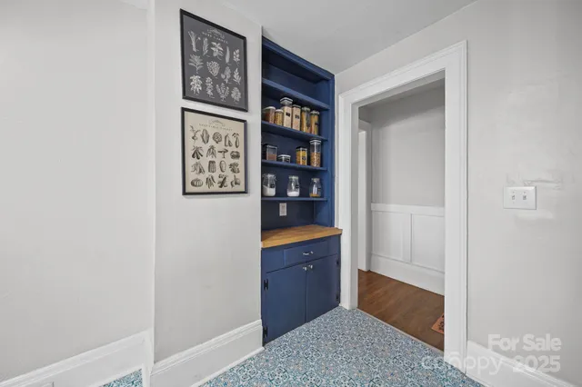 a room with painting on the wall and a window