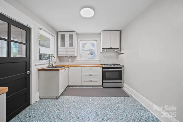 a kitchen with stainless steel appliances granite countertop a stove and white cabinets