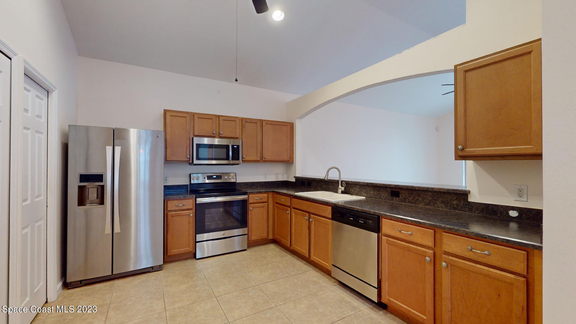 3151 Arden Circle Melbourne, FL 32934 - Photo 11 of 32 a kitchen with stainless steel appliances granite countertop a refrigerator and a sink