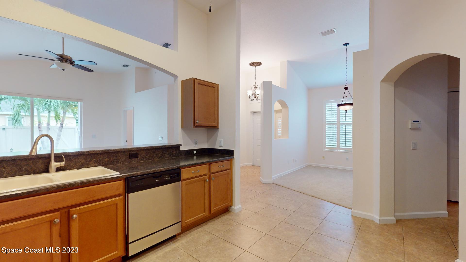 3151 Arden Circle Melbourne, FL 32934 - Photo 12 of 32 a kitchen with stainless steel appliances granite countertop a sink and a refrigerator