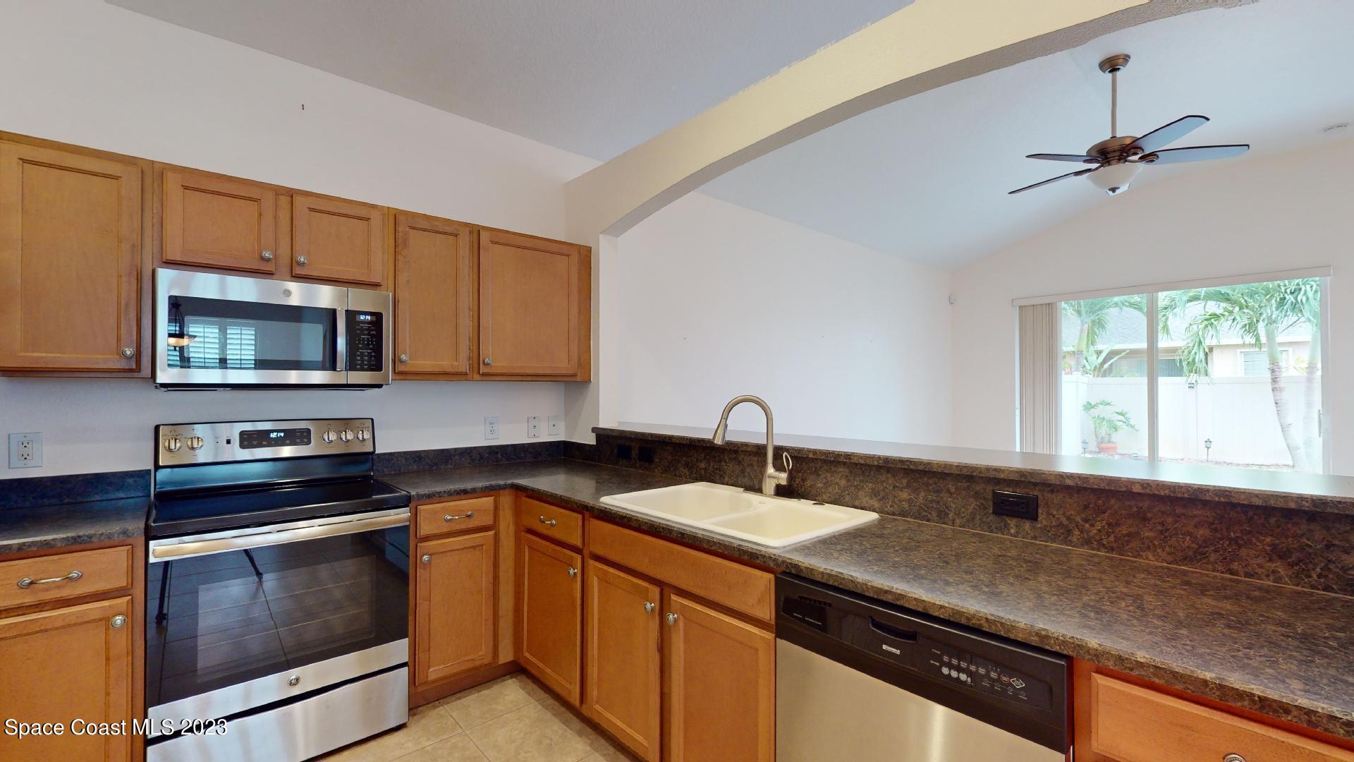 3151 Arden Circle Melbourne, FL 32934 - Photo 13 of 32 a kitchen with stainless steel appliances granite countertop a sink stove and microwave