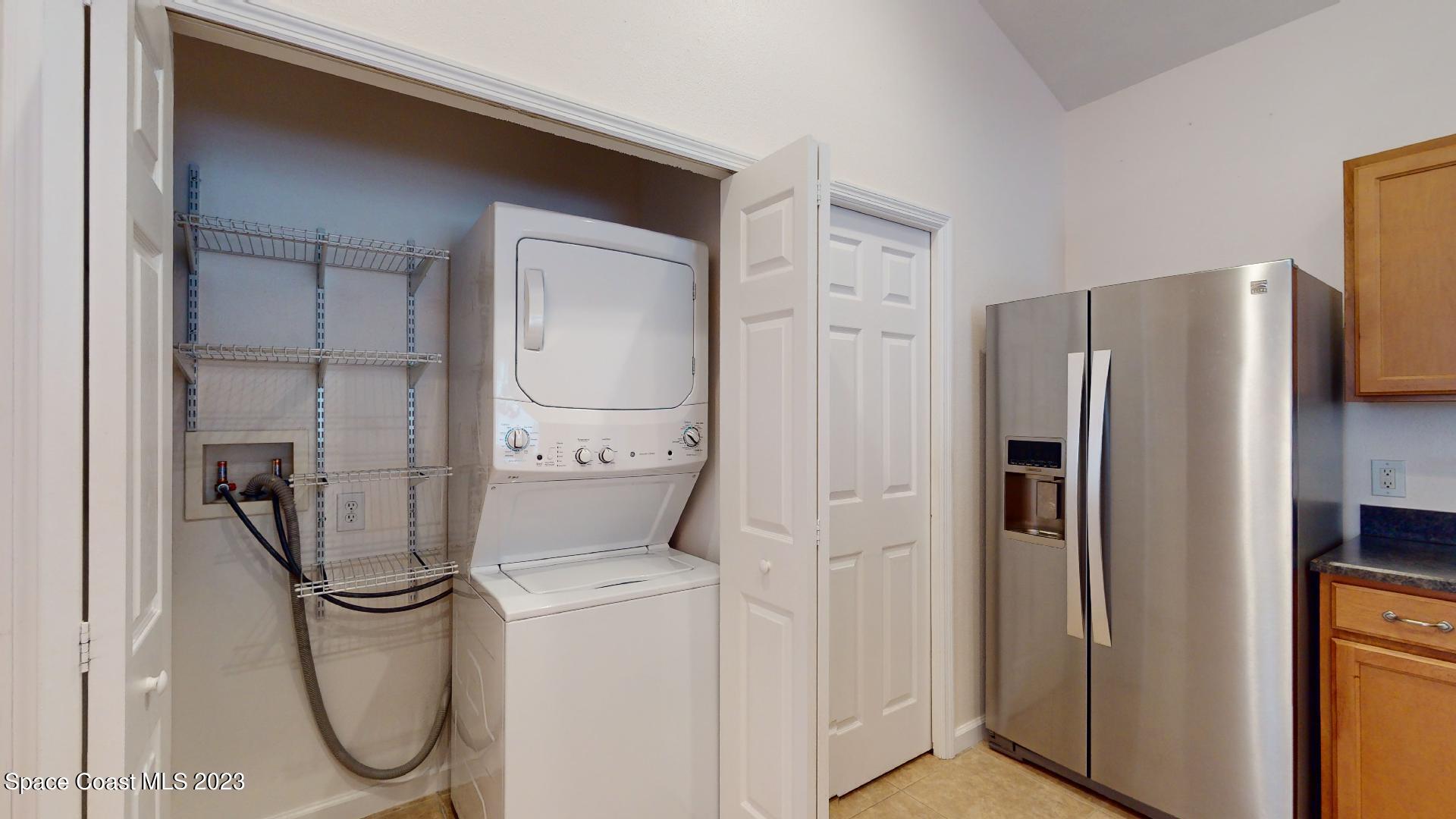 3151 Arden Circle Melbourne, FL 32934 - Photo 14 of 32 a kitchen with a refrigerator and washer