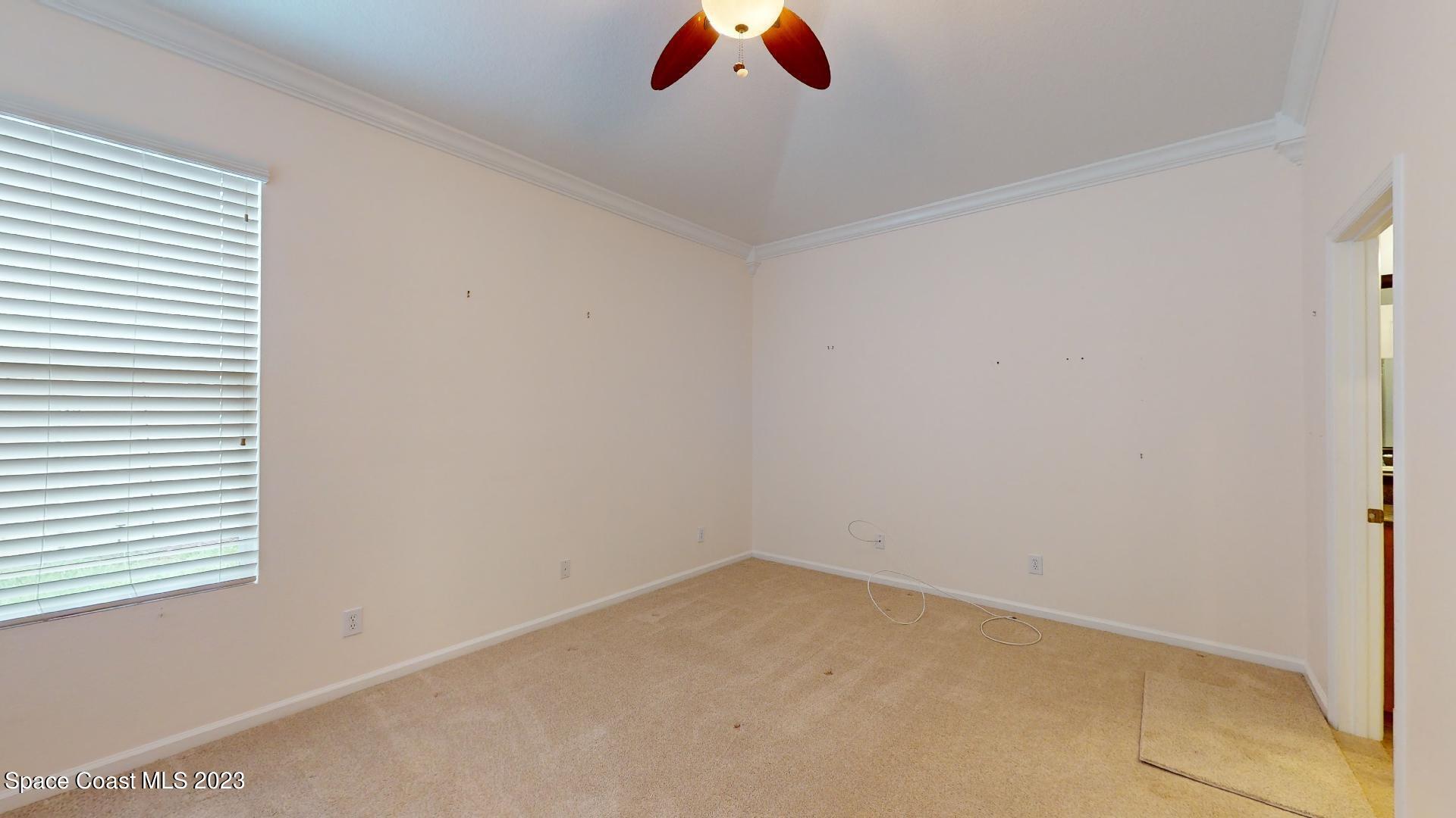 3151 Arden Circle Melbourne, FL 32934 - Photo 19 of 32 an empty room with a ceiling fan and window