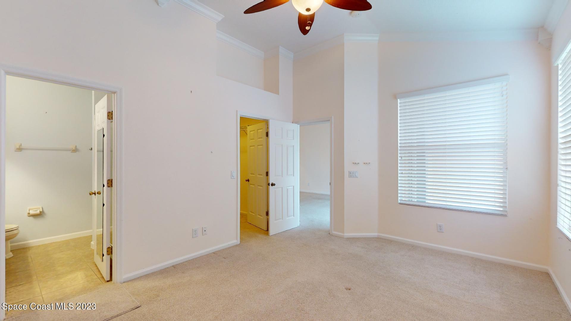 3151 Arden Circle Melbourne, FL 32934 - Photo 22 of 32 a view of an empty room with window and chandelier fan