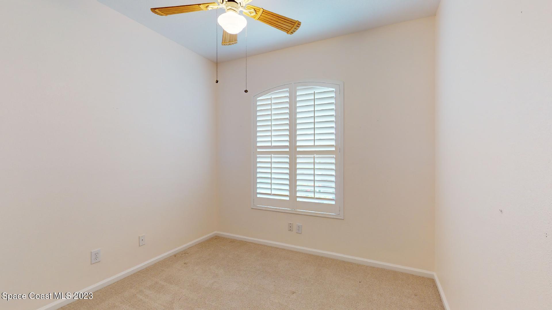 3151 Arden Circle Melbourne, FL 32934 - Photo 25 of 32 an empty room with windows and chandelier