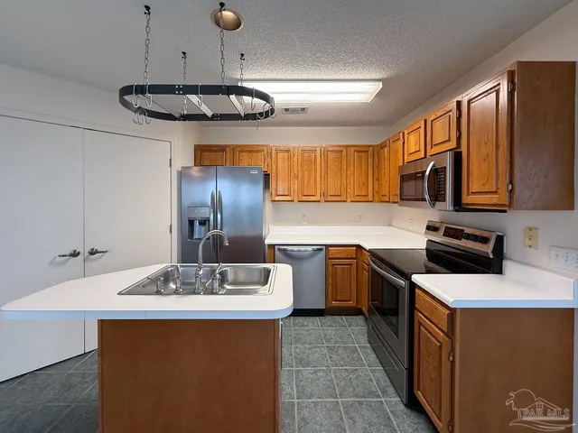 a kitchen with stainless steel appliances a sink stove and refrigerator