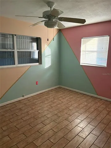 a view of a room that has a fan and window