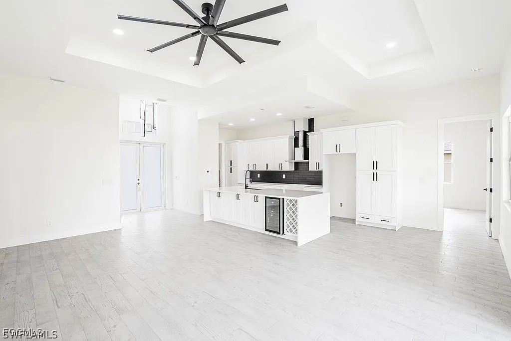2912 45th Street Southwest Lehigh Acres, FL 33976 - Photo 5 of 12 a view of kitchen with white cabinets and wooden floor