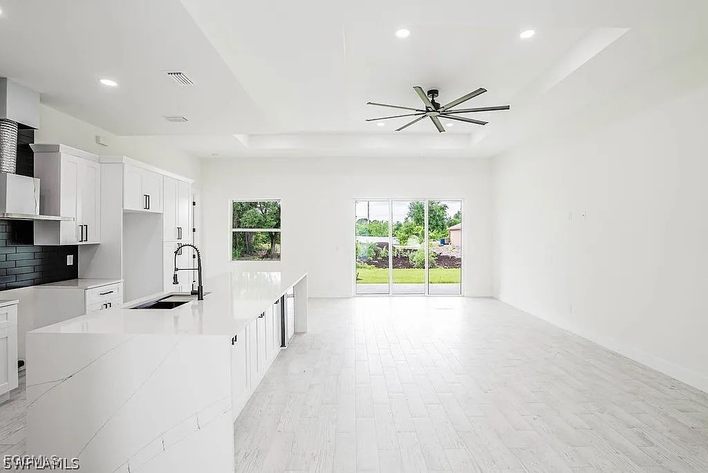 2912 45th Street Southwest Lehigh Acres, FL 33976 - Photo 6 of 12 wooden floor in an empty room with a window