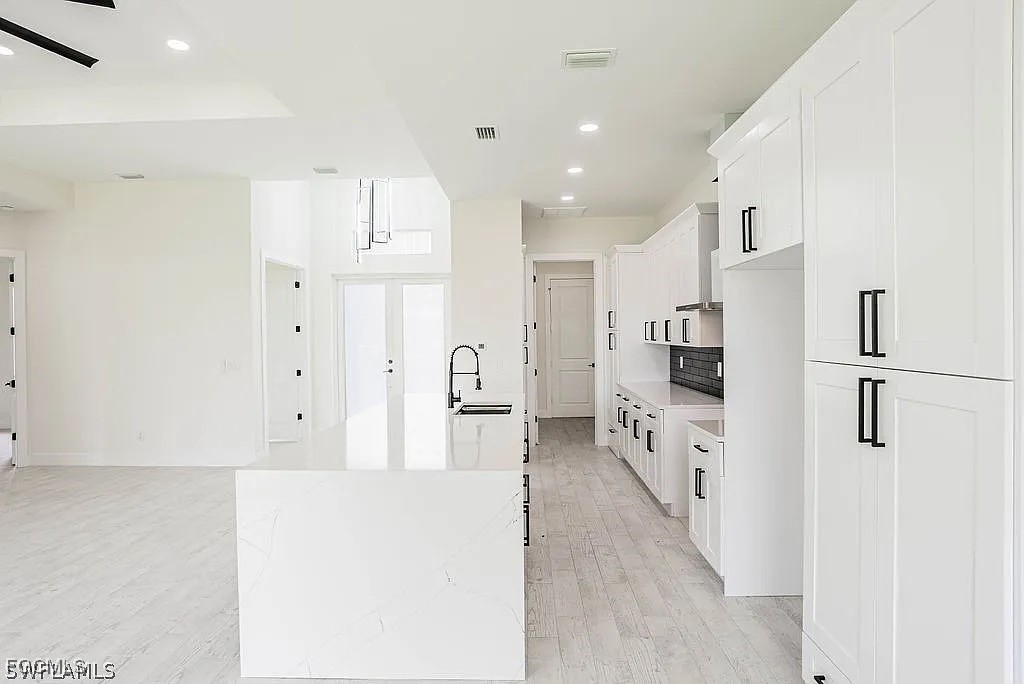 2912 45th Street Southwest Lehigh Acres, FL 33976 - Photo 7 of 12 a large white kitchen with stainless steel appliances a refrigerator and a stove