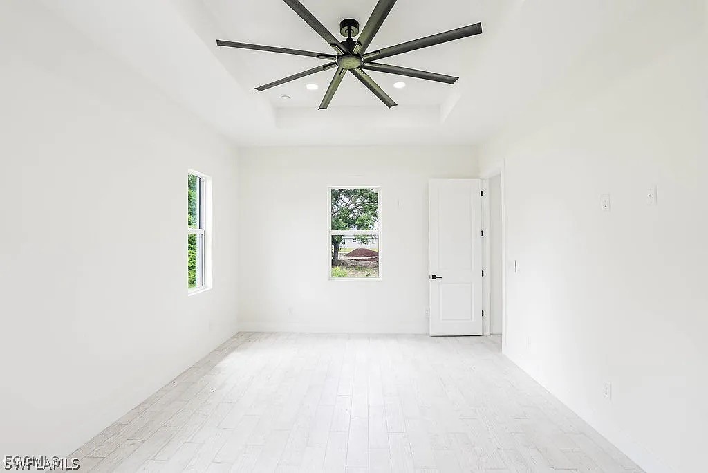 2912 45th Street Southwest Lehigh Acres, FL 33976 - Photo 8 of 12 an empty room with windows and fan