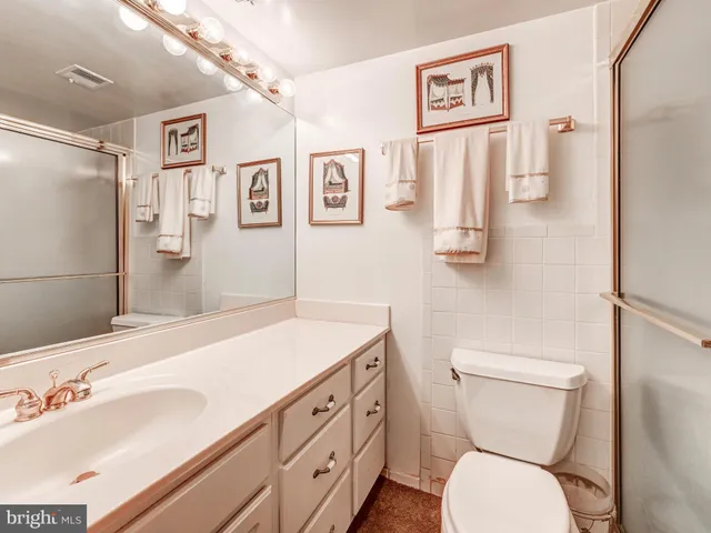 a bathroom with a sink vanity mirror and toilet
