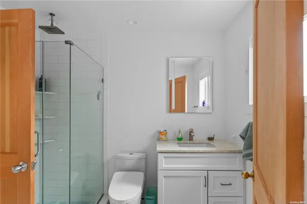 a bathroom with a toilet a sink and mirror