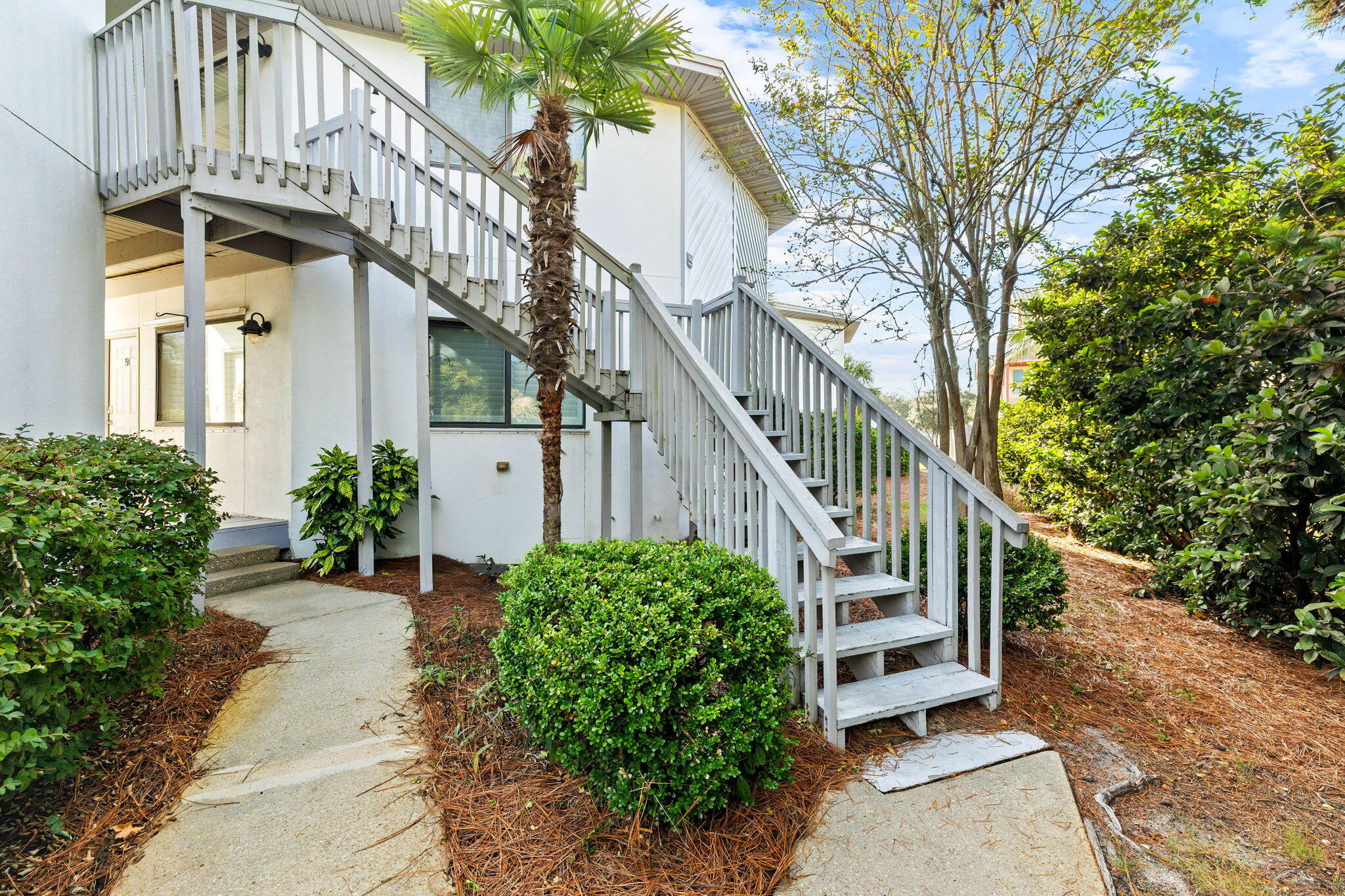 285 Payne Street, Unit 19B Destin, FL 32550 - Photo 20 of 29 a view of a house with a small yard and large trees