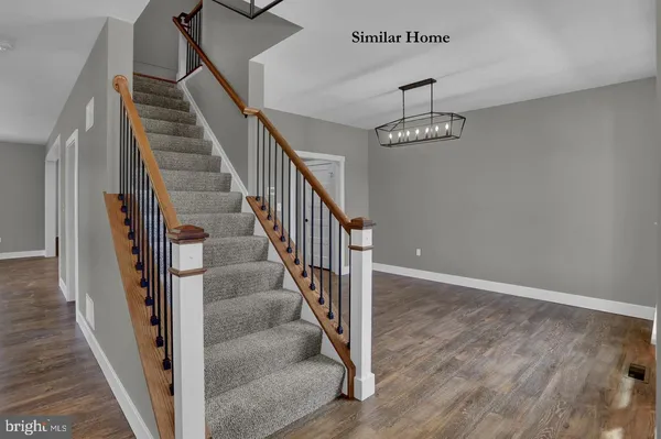 a view of staircase with wooden floor and a chandelier