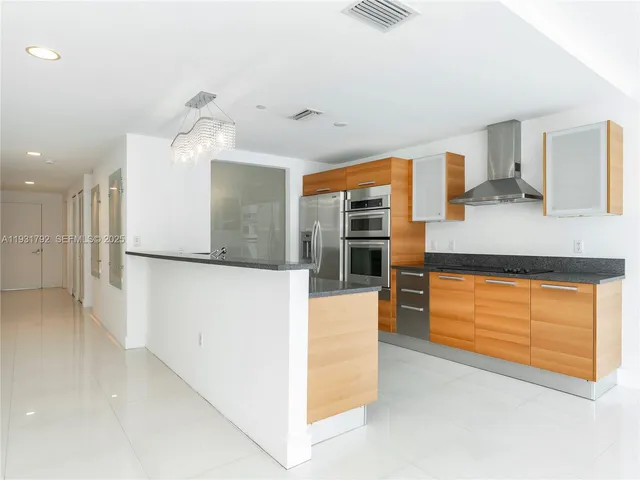 a kitchen with stainless steel appliances granite countertop a sink and a refrigerator