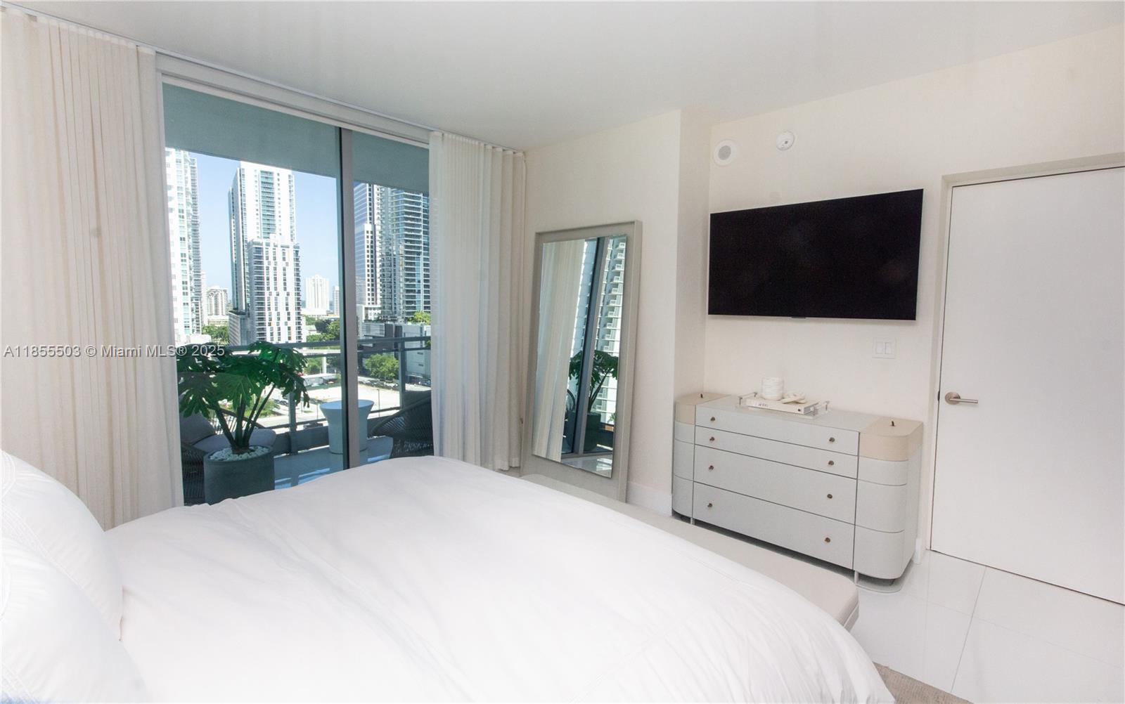 92 Southwest 3rd Street, Unit 1711 Miami, FL 33130 - Photo 19 of 54 a bedroom with a bed and a flat screen tv