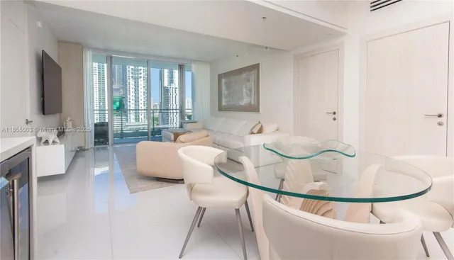 a kitchen with stainless steel appliances kitchen island granite countertop a table chairs and a refrigerator