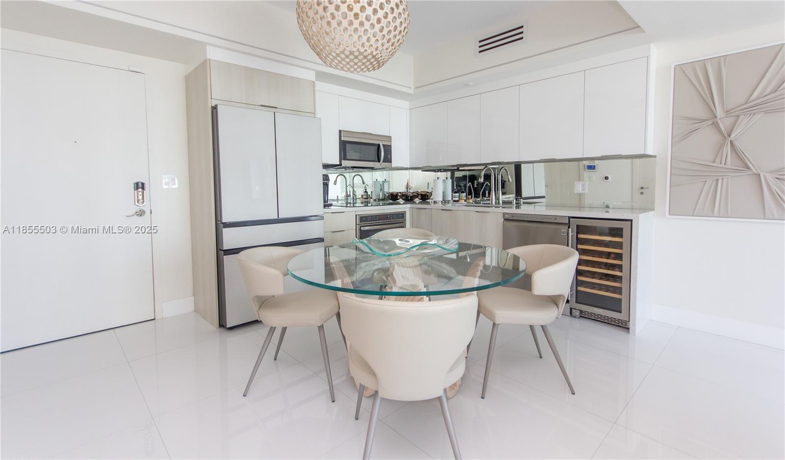 92 Southwest 3rd Street, Unit 1711 Miami, FL 33130 - Photo 9 of 54 a kitchen with stainless steel appliances kitchen island granite countertop a table chairs and a refrigerator