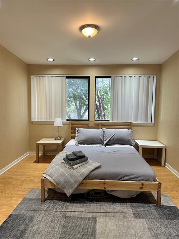 4926 Thunder Road Dallas, TX 75244 - Photo 11 of 16 a bedroom with a bed and wooden floor