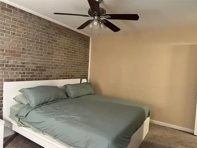a bedroom with a bed and a ceiling fan