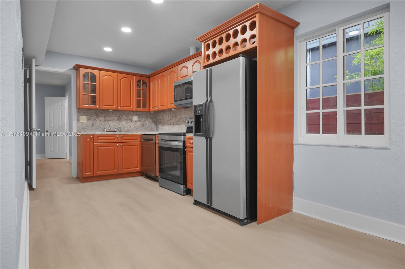 a kitchen with stainless steel appliances granite countertop a refrigerator and a sink