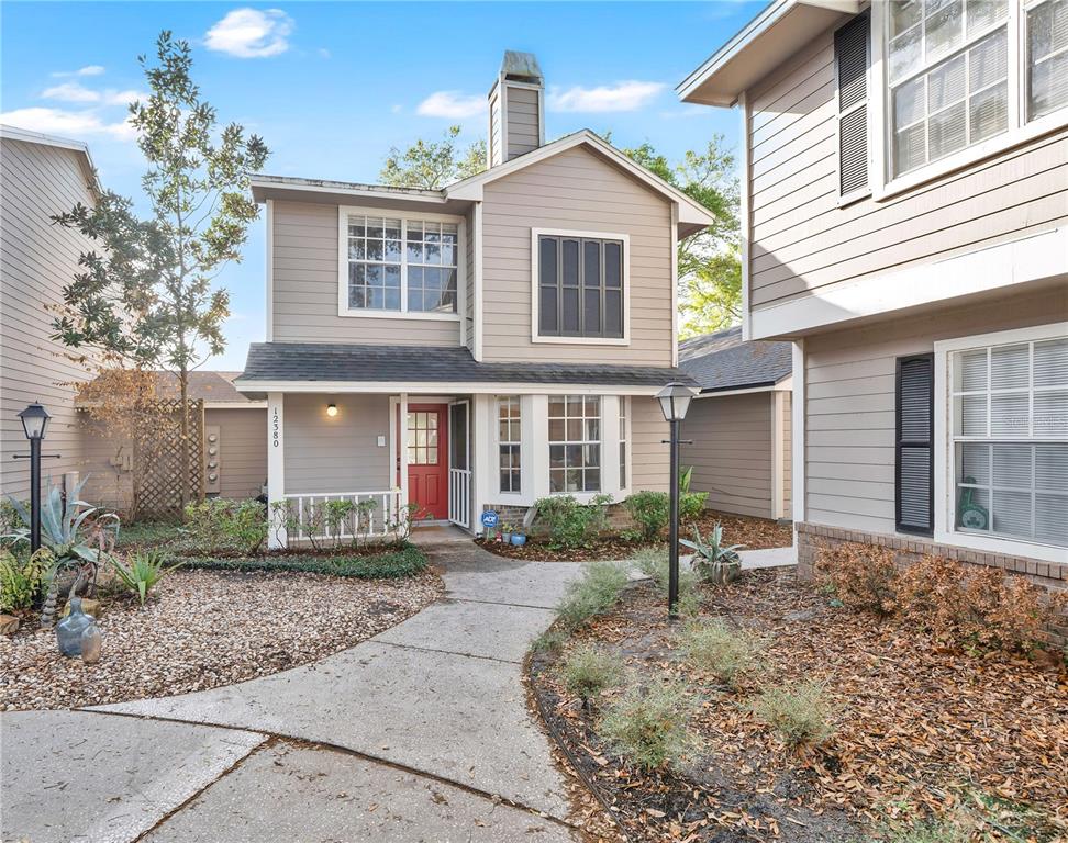 12380 Shady Spring Way, Unit 105 Orlando, FL 32828 - Photo 1 of 1 a front view of a house with garden