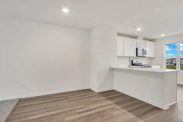 a kitchen with granite countertop white cabinets and white appliances