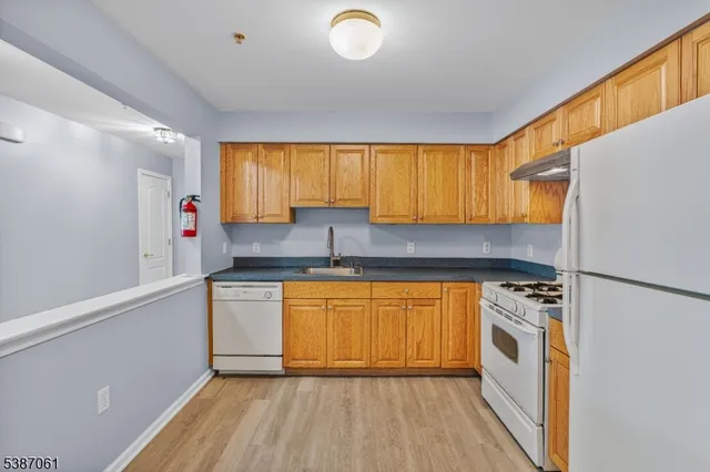 a kitchen with stainless steel appliances granite countertop a sink and a refrigerator