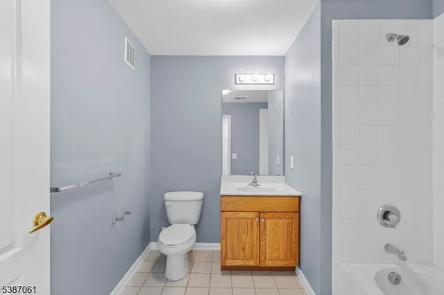 a bathroom with a granite countertop toilet and a sink