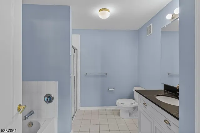 a bathroom with a granite countertop toilet a sink and a mirror