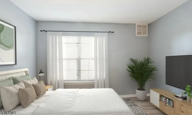 a bedroom with a large bed and a flat tv screen