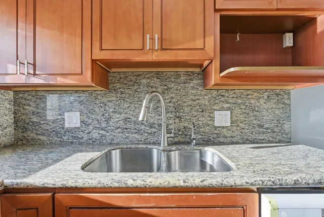 a kitchen with granite countertop a sink and cabinets