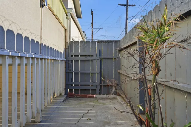 a view of a house with a small yard and wooden fence