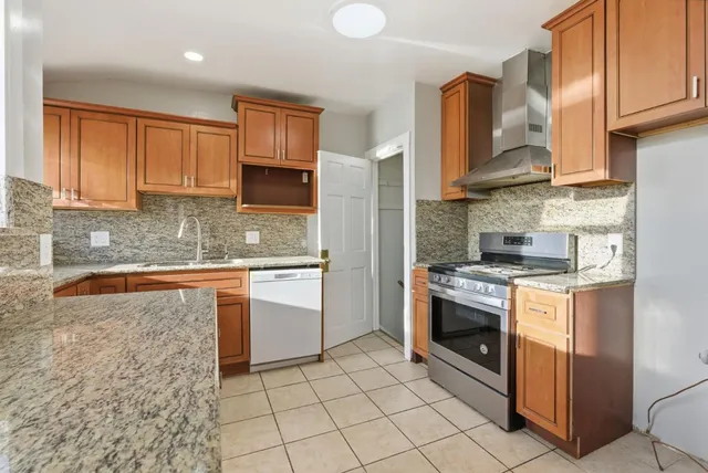 a kitchen with stainless steel appliances granite countertop a stove a sink and a microwave