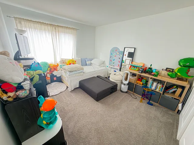 a living room with furniture toys and a window