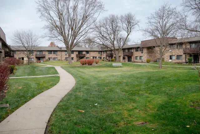 a view of a big building with a big yard and large trees