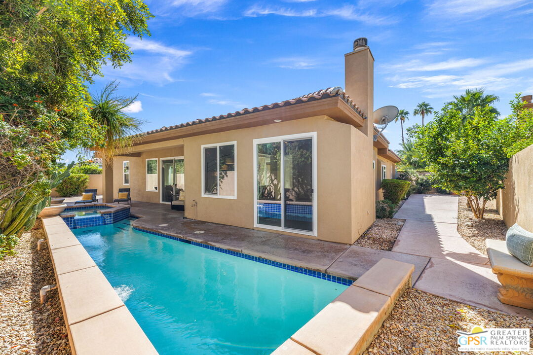 a view of a house with backyard and sitting area