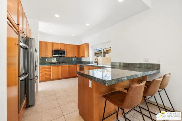 a kitchen with stainless steel appliances granite countertop a sink and a microwave