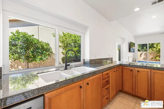 a kitchen with stainless steel appliances granite countertop a refrigerator and a sink
