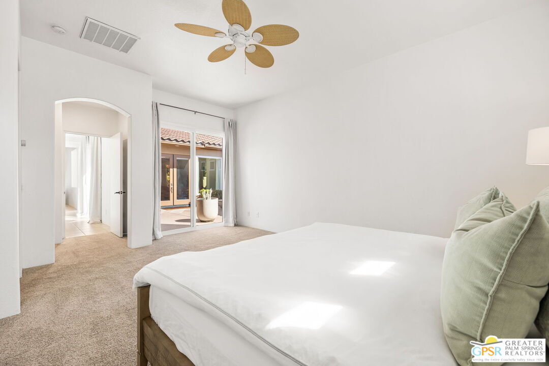 30 Vía Cielo Azul Palm Desert, CA 92260 - Photo 27 of 40 a bedroom with a large bed and a chandelier