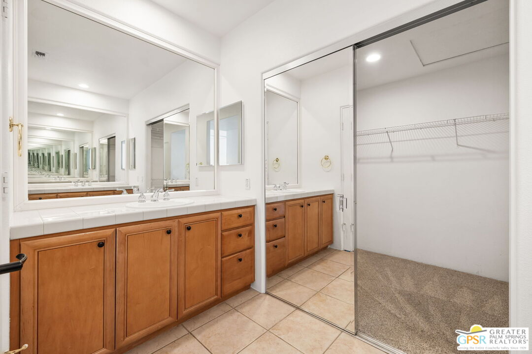 30 Vía Cielo Azul Palm Desert, CA 92260 - Photo 32 of 40 a large bathroom with a granite countertop sink two mirror and a tub