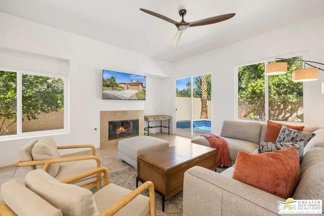 a living room with furniture a fireplace and a large window