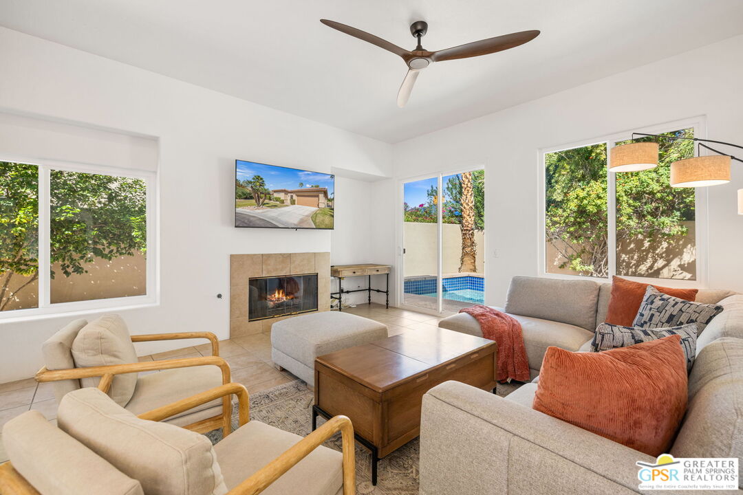 30 Vía Cielo Azul Palm Desert, CA 92260 - Photo 4 of 40 a living room with furniture a fireplace and a large window