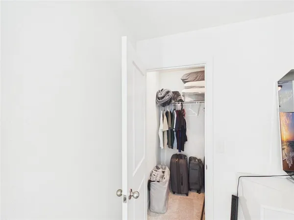 a view of walk in closet with clothes and shoes