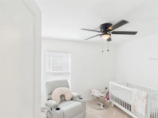 a bathroom with a baby crib and a fan