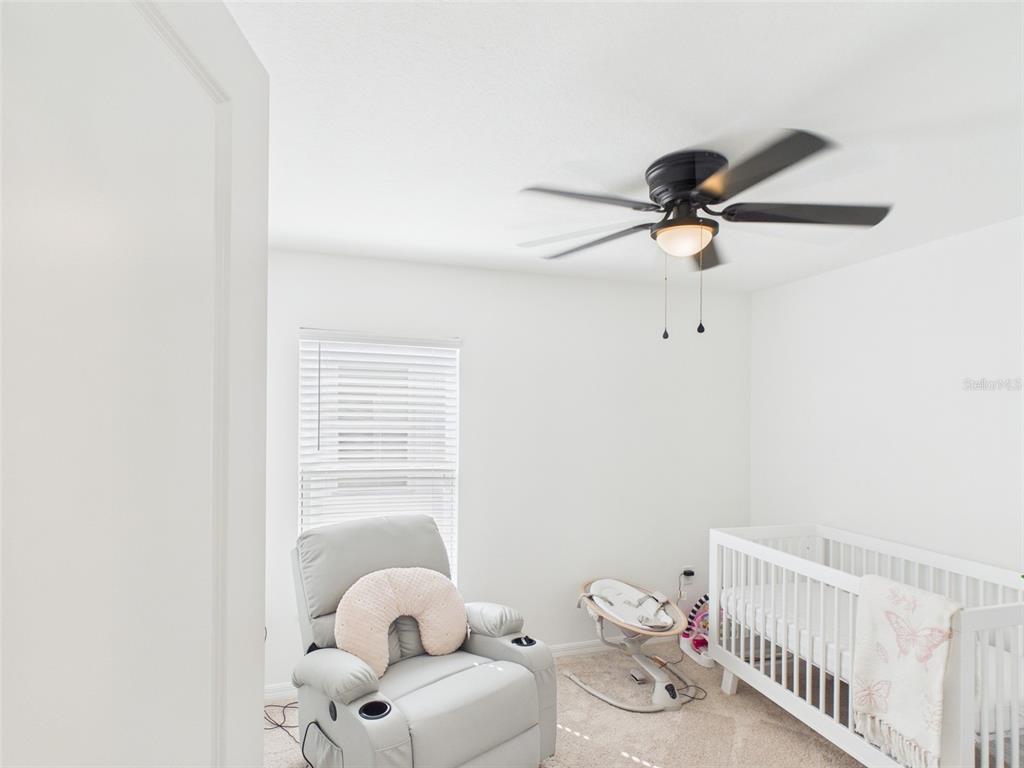 5194 Sailor Road Brooksville, FL 34602 - Photo 13 of 26 a bathroom with a baby crib and a fan