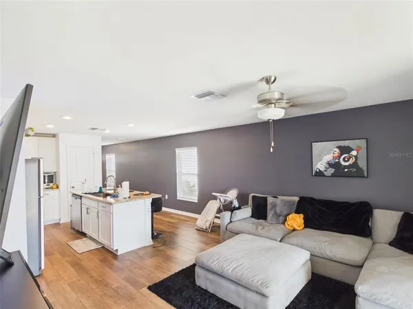a living room with furniture and kitchen view
