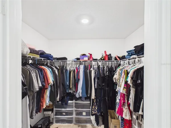 a view of walk in closet with clothes